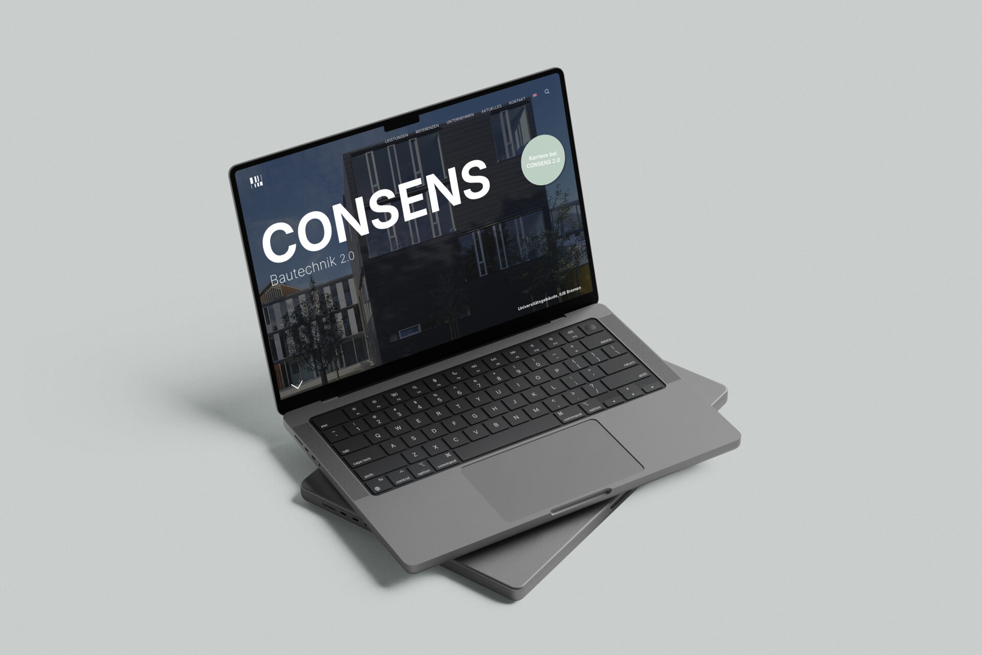 Laptop mit dem Schriftzug "CONSENS" auf dem Bildschirm, präsentiert auf einem grauen Hintergrund. Ideal für Themen zu Technologie und digitales Design.
